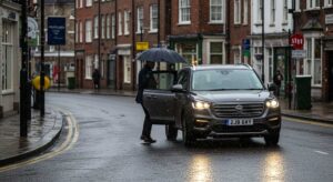 Frimley taxis driving safely on a wet, rainy road.